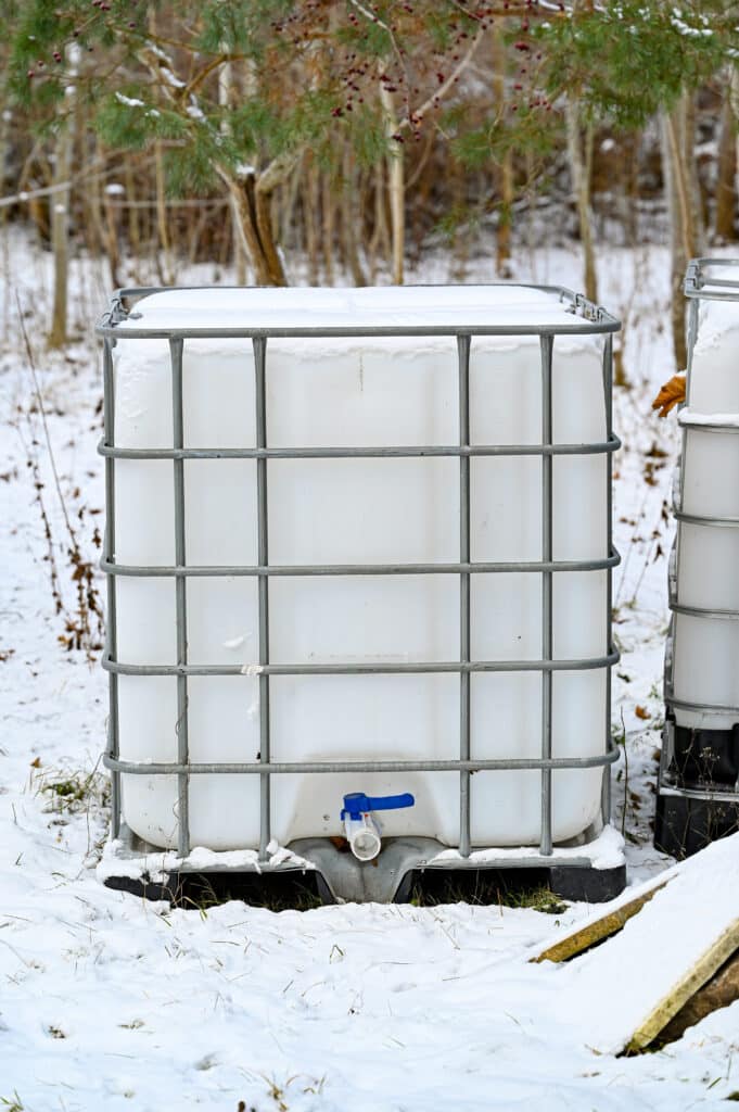 big white tank with tap for a cubic of water standing outdoor