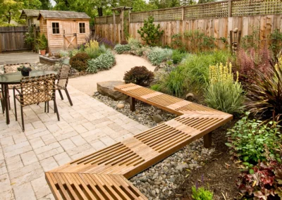beautiful native landscaping backyard with small wooden shed, fence and pathway